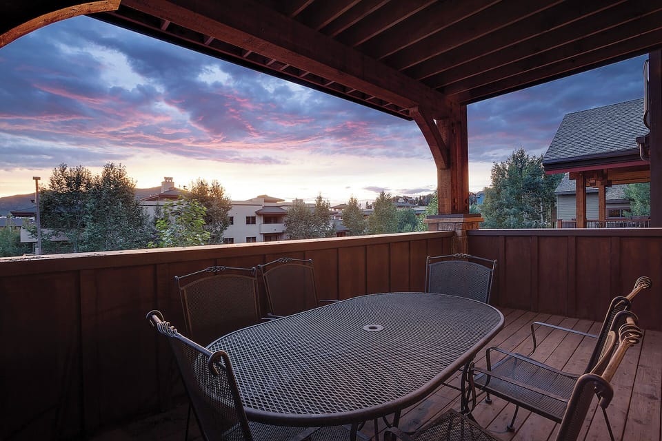 Covered balcony overlooking the surrounding neighborhood as the sky glows with pink and blue hues—a peaceful retreat for morning coffee or evening unwinding.