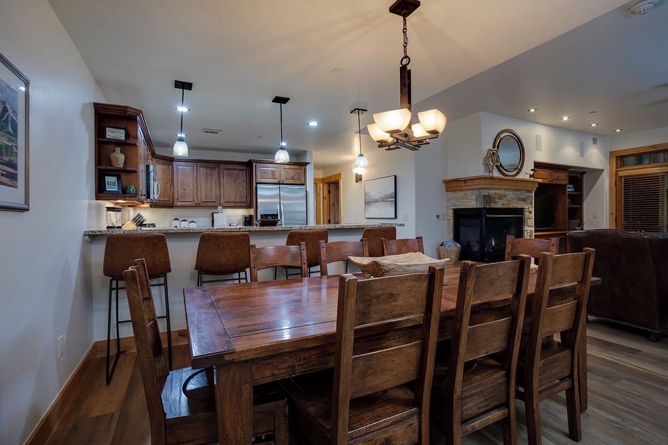 Gather around the spacious dining table and cook together in the open kitchen, with a cozy fireplace and vaulted ceilings setting the scene for memorable meals.