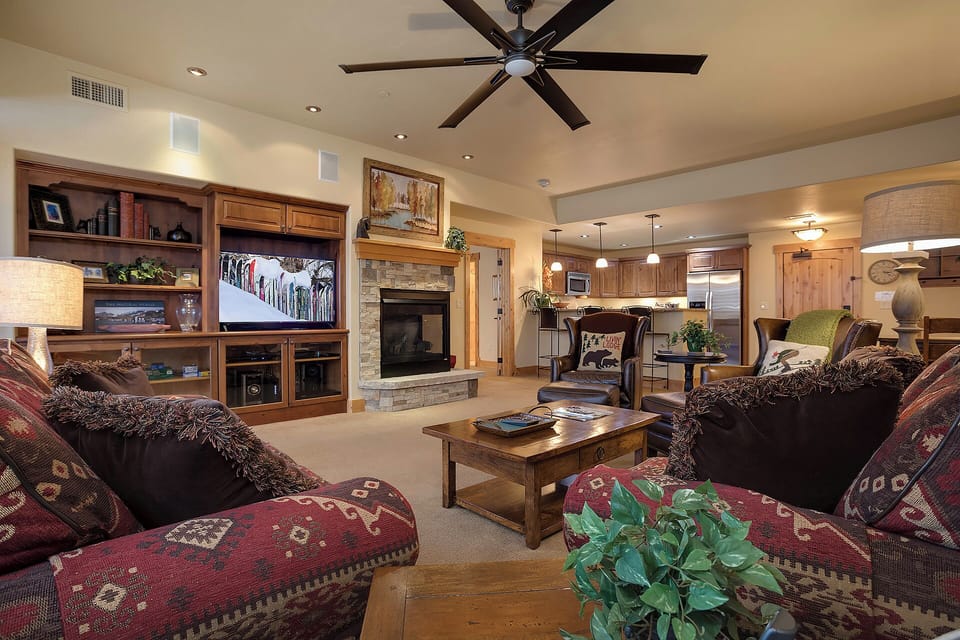 Relax in your spacious living area with plush seating, a cozy fireplace, and a ceiling fan to keep you comfortable all year long.