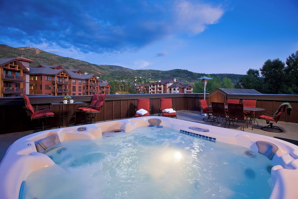 Rooftop hot tub with mountain views and comfortable seating creates a relaxing alpine retreat. The perfect spot to unwind after exploring the surrounding valley and nearby properties.