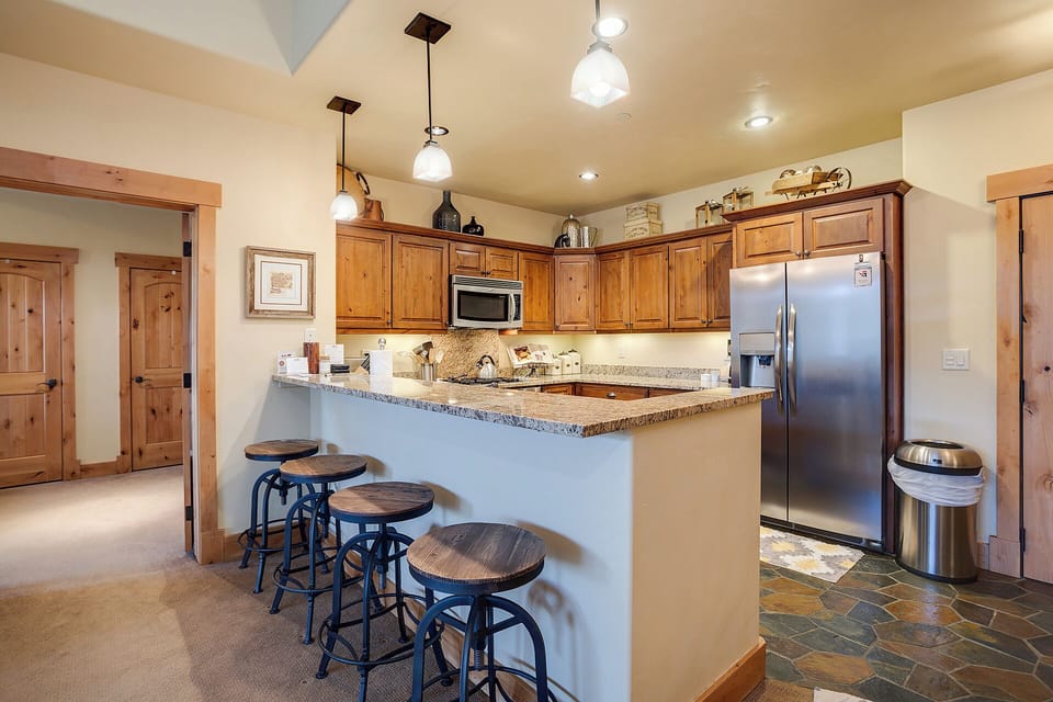 Your fully equipped kitchen invites easy meal prep with granite countertops, stainless appliances, and a breakfast bar where you can gather for casual bites and morning coffee together.