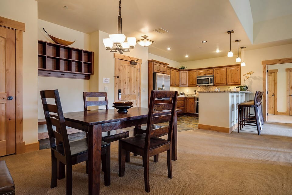Gather around the spacious dining table and enjoy meals together in this warm, open-concept space with a fully equipped kitchen ready for your culinary adventures.