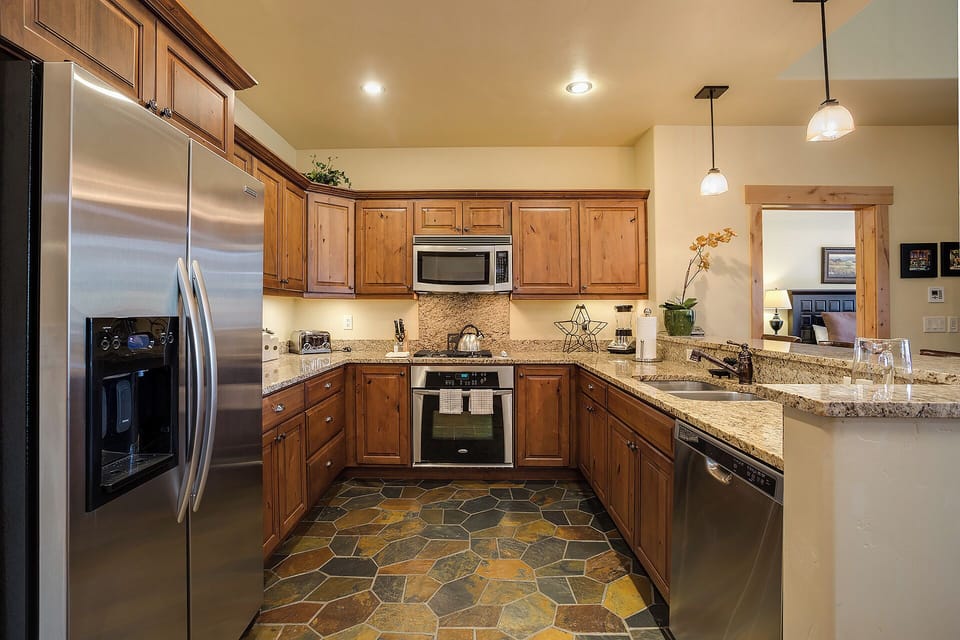 Your fully equipped kitchen features granite countertops, stainless appliances, and warm wood cabinetry—everything you need to cook comfortably and feel right at home during your stay.