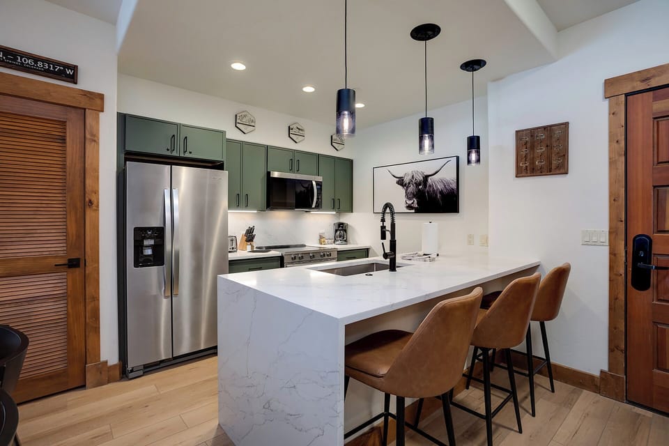 Your fully equipped kitchen awaits with modern appliances, sleek marble countertops, and stylish pendant lighting. Gather at the island bar for morning coffee or casual meals in this inviting space.