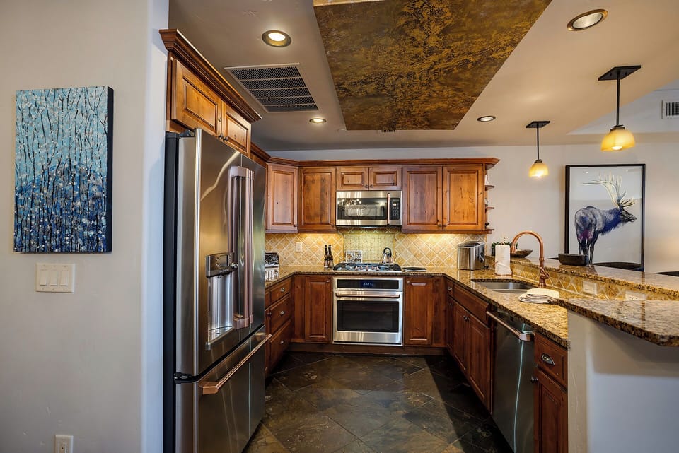 Your gourmet kitchen awaits with granite countertops, stainless-steel appliances, and warm wood cabinetry—perfect for preparing meals in elegant comfort.