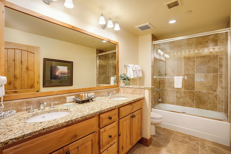 Refresh in your private bathroom with warm wood cabinetry, granite counters, and a full tub-shower combo—perfect after a day exploring nearby trails.