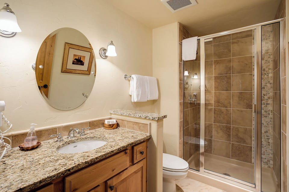 Refresh in your private bathroom featuring granite counters, soft towels, and a spacious walk-in shower with beautiful tile work that makes every morning feel like a spa retreat.