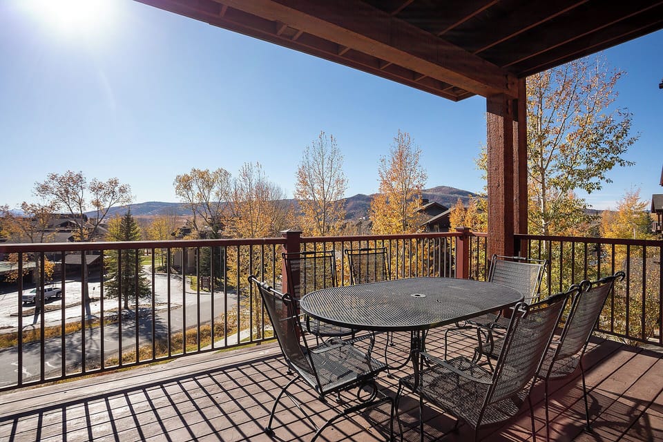 Stunning mountain views frame this covered balcony with outdoor dining for six, perfect for enjoying crisp autumn mornings or starlit dinners in the fresh alpine air.
