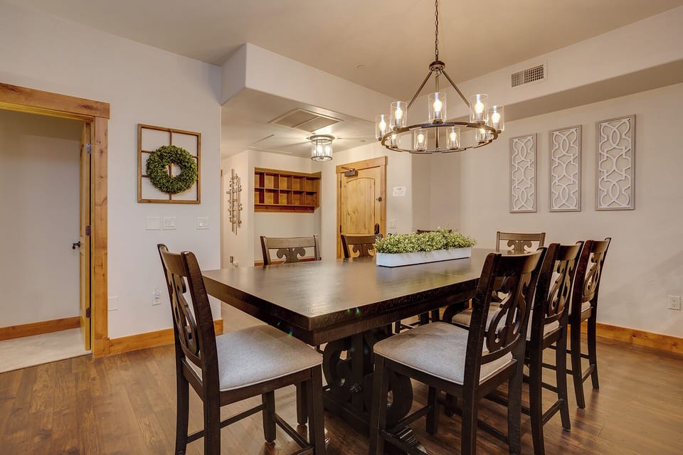 Gather around this spacious dining table for memorable meals together. The rustic chandelier and warm wood accents create an inviting atmosphere where your group can reconnect.