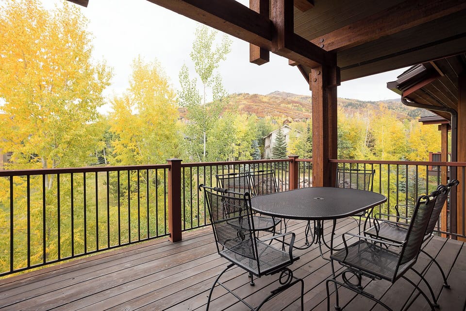 Sip your morning coffee on this covered balcony, where golden aspens frame mountain views and fresh air surrounds your outdoor dining experience.
