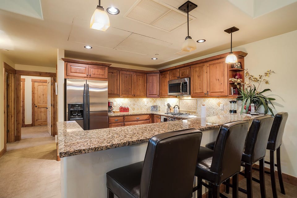 Your gourmet kitchen features granite countertops, stainless steel appliances, and a breakfast bar perfect for morning coffee or casual meals with family and friends.