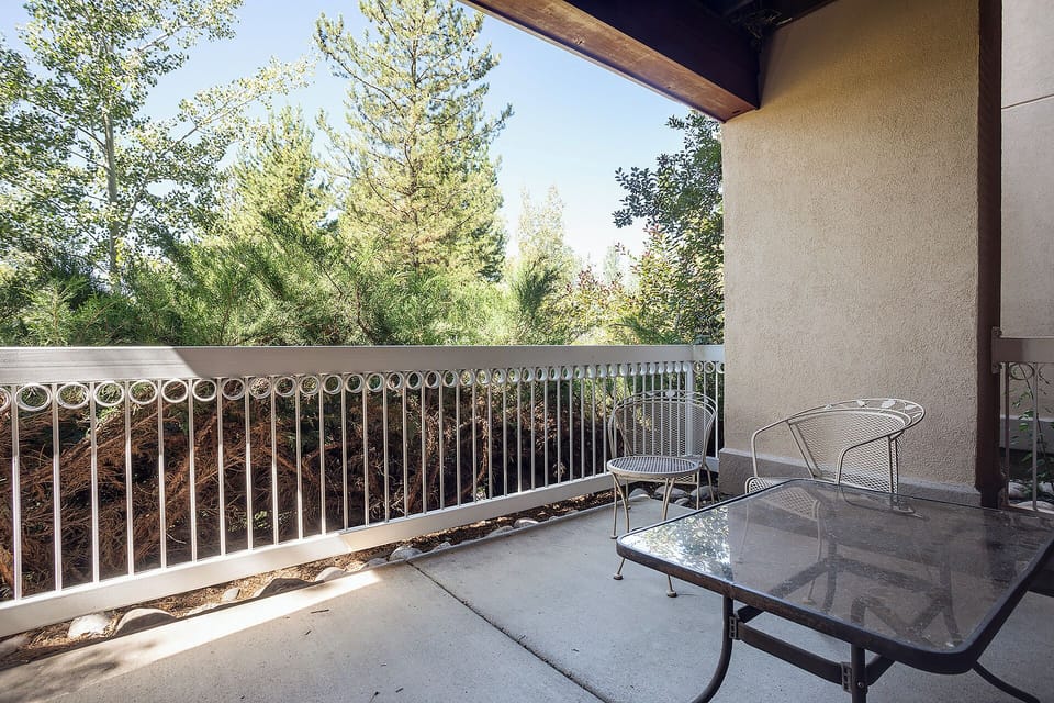 Step onto your private covered balcony, where bistro seating invites morning coffee amid serene treetop views. The peaceful natural surroundings create your perfect escape.