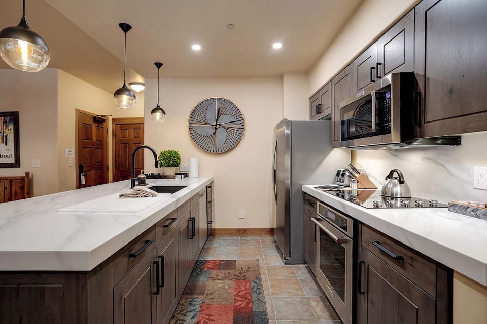 Imagine whipping up your favorite meals in this spacious, well-equipped kitchen. Sleek countertops, modern appliances, and stylish lighting create a welcoming space where you'll love cooking.