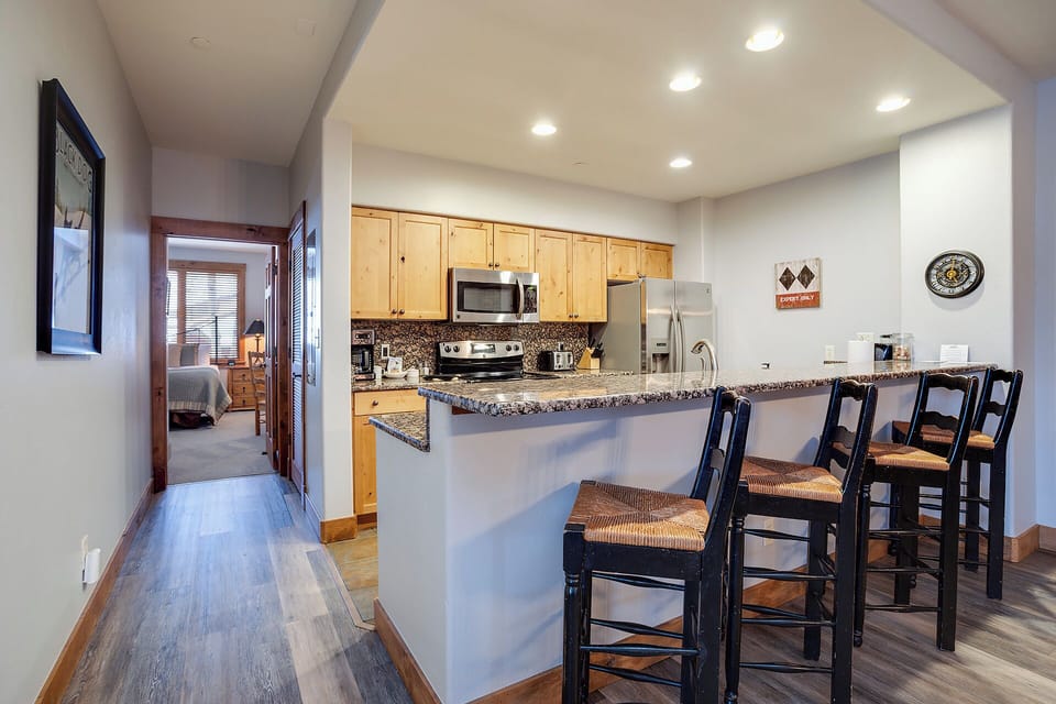 Your open kitchen features granite countertops, modern appliances, and a breakfast bar with seating—perfect for casual meals and morning coffee.