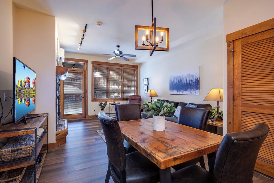 Your cozy retreat with warm wood accents, a stunning rustic dining table, and inviting living space perfect for unwinding after mountain adventures.
