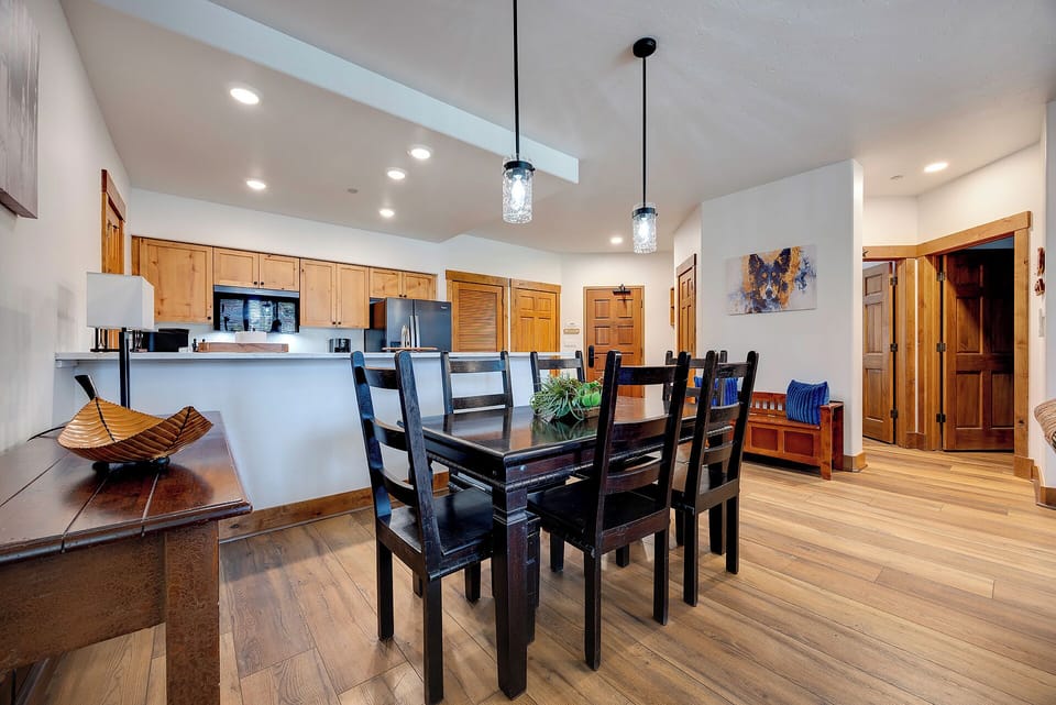 Gather around this spacious dining table where your group can share meals and make memories together. The open layout flows seamlessly into the kitchen, creating a warm, inviting atmosphere for your mountain getaway.