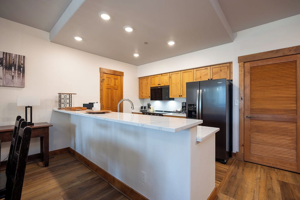 Gather around your spacious kitchen island with gleaming white countertops, perfect for preparing meals and sharing stories. The bright, open layout invites you to cook and connect comfortably.