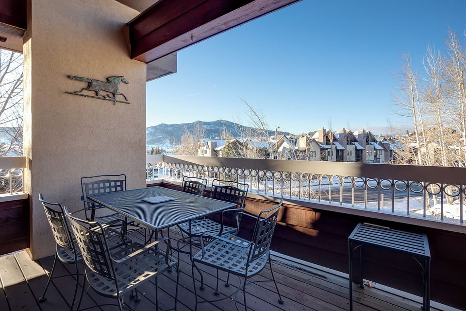 A covered terrace with mountain and lake views frames a peaceful winter morning. Dine outdoors at the table for six or relax while taking in the surrounding alpine scenery.