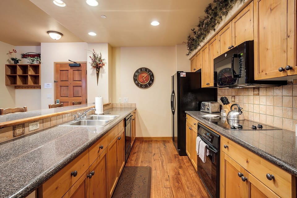 Your fully equipped kitchen invites you to prepare favorite meals with modern appliances, granite countertops, and warm wood cabinetry—perfect for family gatherings or quiet mornings.