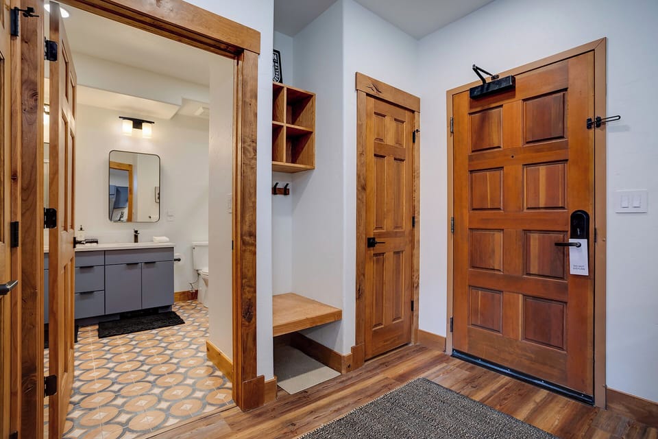 Step into a welcoming entryway with warm wood tones and thoughtful design. Your private bathroom awaits just steps away, while built-in cubbies keep your belongings organized throughout your stay.