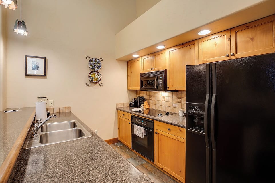 Your fully equipped kitchen features warm wood cabinetry, granite counters, stainless steel appliances, and everything you need to prepare meals just like home.