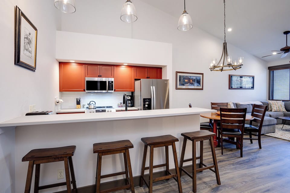 An open concept design connects your modern kitchen, breakfast bar, and living spaces—perfect for gathering with family and sharing meals together in one warm, airy setting.
