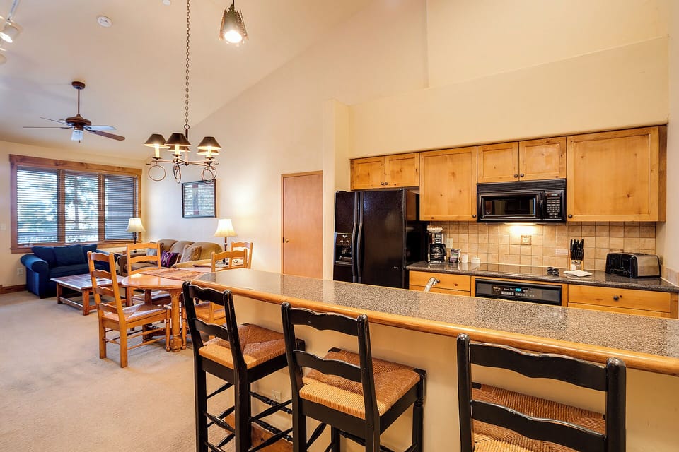 Your open-concept retreat blends comfort and convenience with a fully equipped kitchen, breakfast bar seating, and a cozy dining nook—perfect for gathering after mountain adventures.