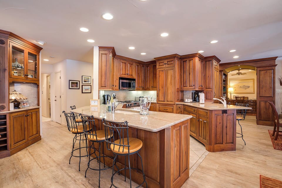 Step into your gourmet kitchen where rich wood cabinetry and granite counters invite you to craft memorable meals with friends and family at the elegant island.