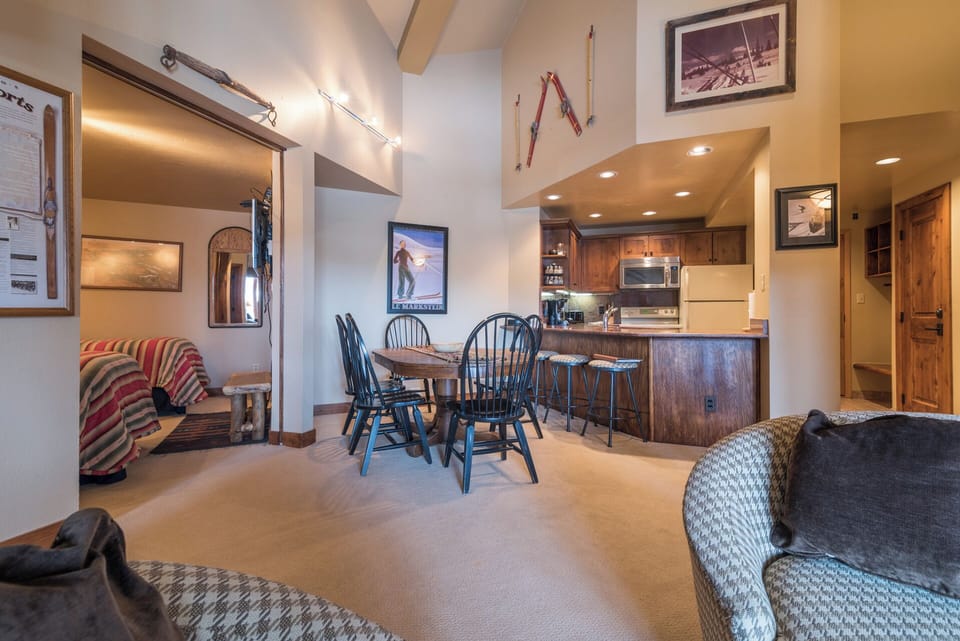 Your cozy mountain retreat features vaulted ceilings, ski-themed décor, and an open layout that connects the dining area to a fully-equipped kitchen—perfect for relaxing after a day on the slopes.