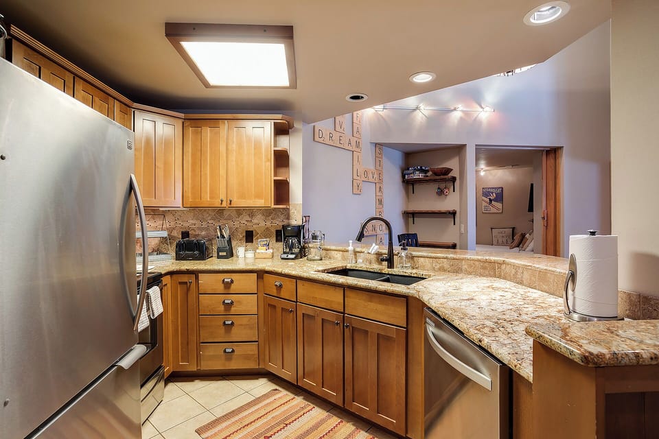 Your fully equipped kitchen features granite countertops, warm wood cabinetry, and modern stainless appliances—perfect for preparing delicious meals during your mountain getaway.