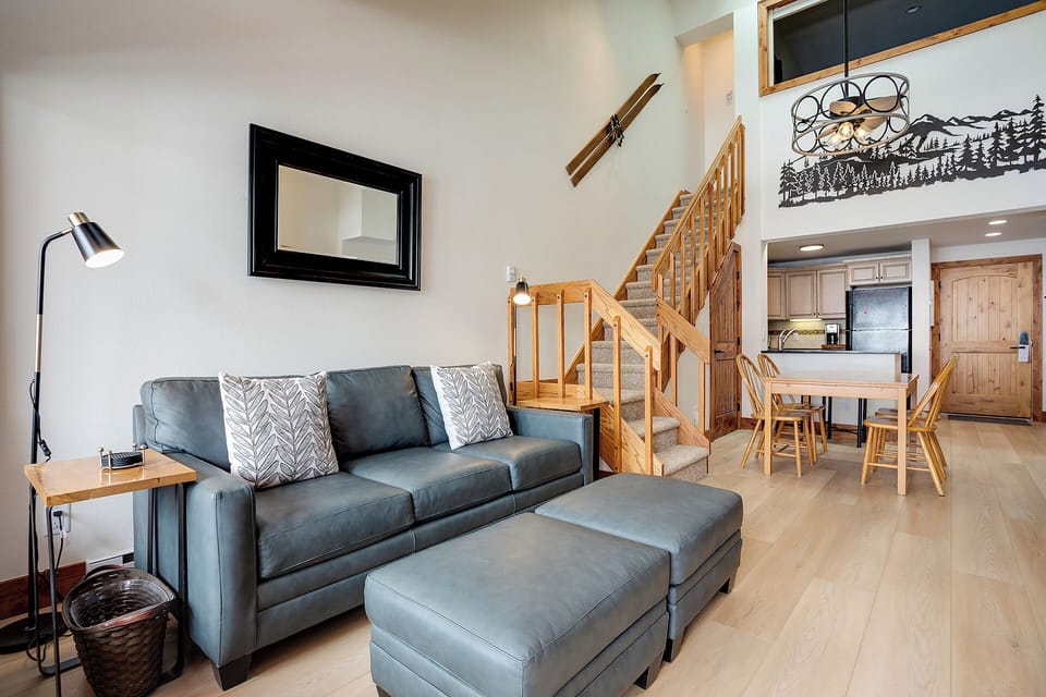 Your mountain retreat awaits with soaring ceilings, cozy seating, and a loft overlooking the warm, open-concept living and dining space—perfect for unwinding after a day on the slopes.
