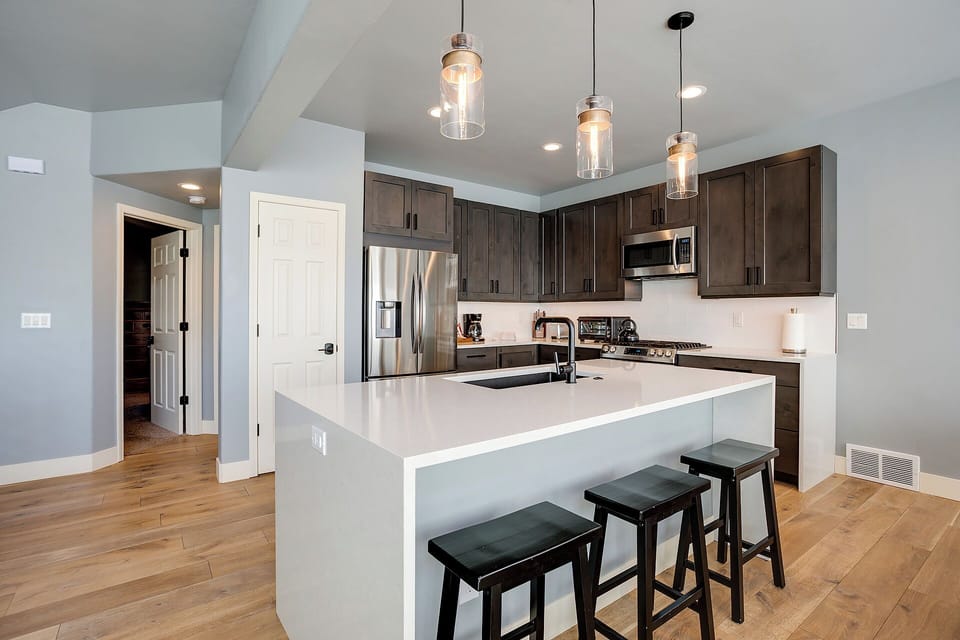 Your gourmet kitchen features sleek quartz countertops, modern pendant lighting, and a spacious island perfect for preparing meals or enjoying morning coffee with family.