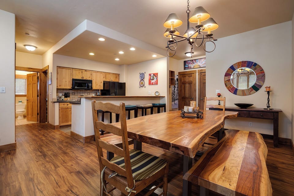 Gather around the rustic wood dining table, where warm pendant lighting and mountain charm set the scene for your group's meals and laughter.