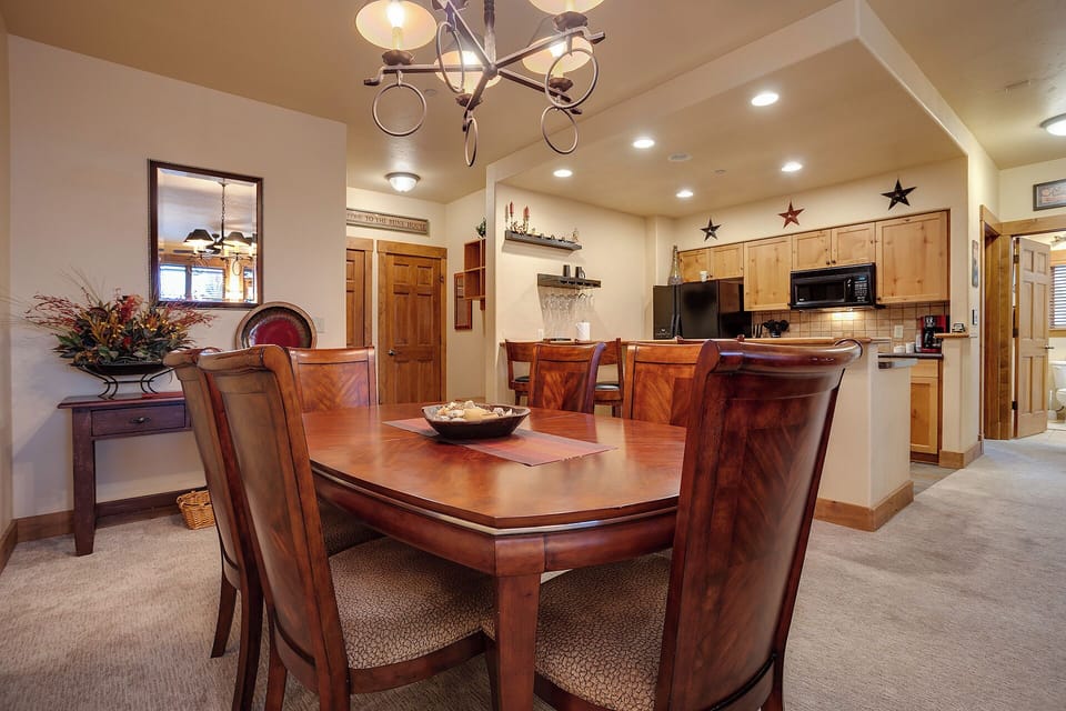 Gather around a beautiful wooden dining table in your open-concept living space, perfect for memorable meals together. The well-equipped kitchen is just steps away, ready for your culinary adventures.