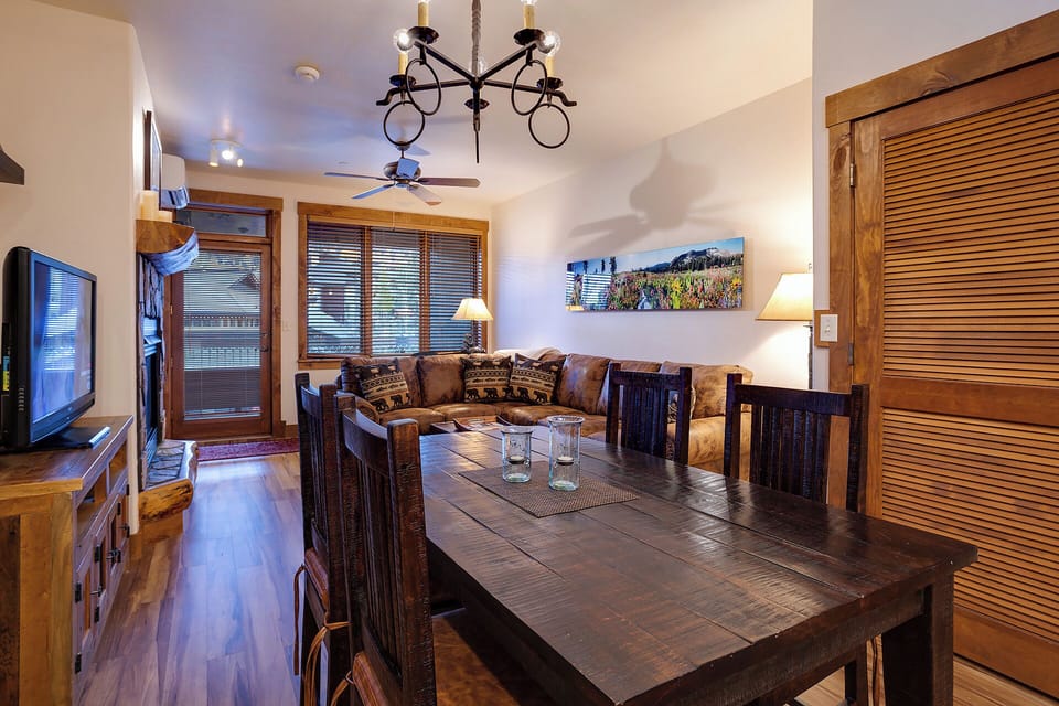 Unwind in your cozy living space with rustic wood touches, a plush leather sofa, and mountain artwork setting the scene for your perfect getaway.