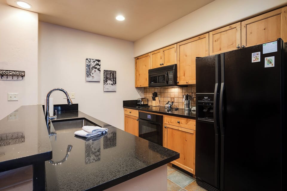 Your fully equipped kitchen features granite counters, warm wood cabinetry, and modern appliances—perfect for preparing meals during your mountain getaway.