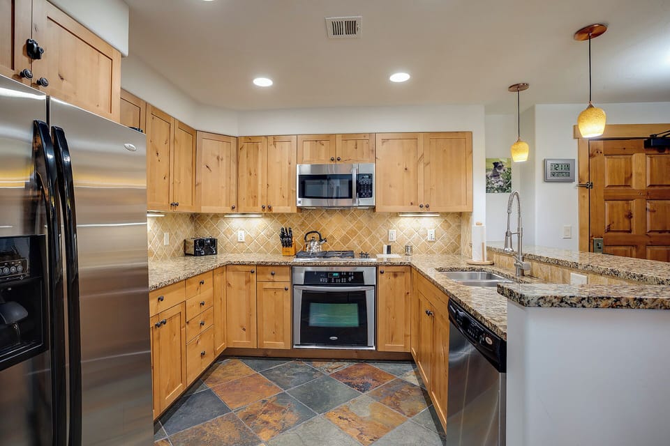 Your chef-inspired kitchen features warm wood cabinetry, granite countertops, and stainless steel appliances—ready to bring your favorite recipes to life.