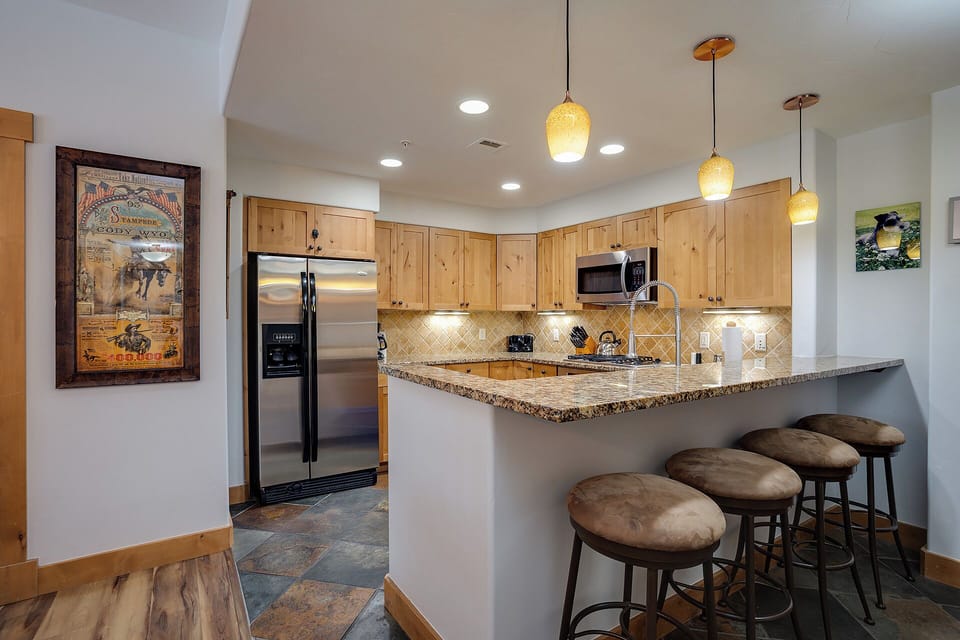 Your fully equipped kitchen features granite counters, modern appliances, and a breakfast bar where you can enjoy morning coffee or casual meals together.