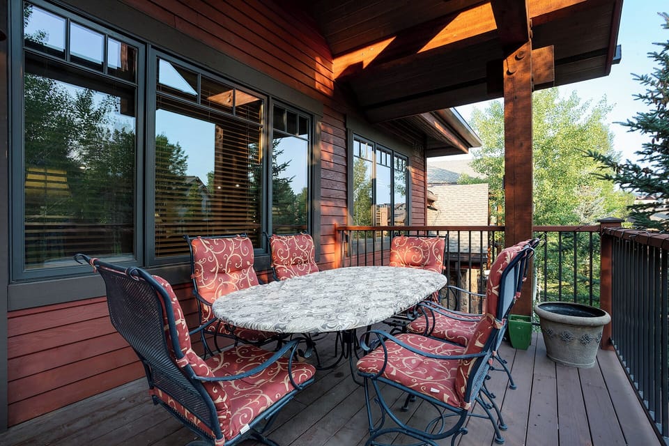 Sip your morning coffee on this sheltered deck surrounded by towering pines. A welcoming table for six invites outdoor meals, with stunning mountain views framing your al fresco dining experience.