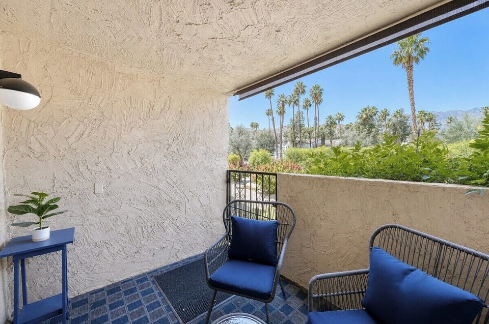 Your private balcony overlooks swaying palms and mountain silhouettes, creating a serene desert oasis perfect for sipping morning coffee or unwinding after a day of adventure.