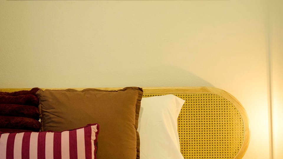 Soft bed headboard and plush pillows.