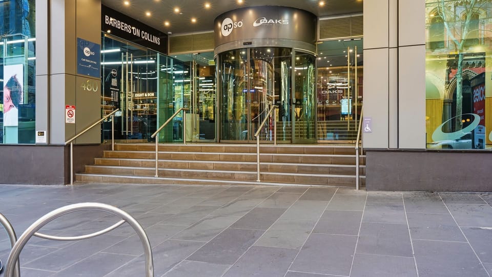 Exterior street-level view of the building entrance with steps.