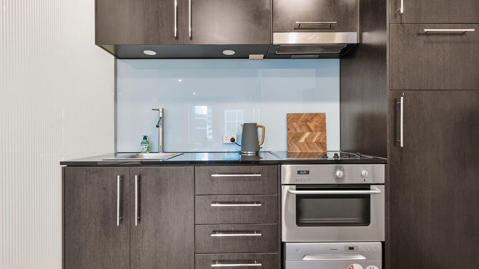 Modern kitchenette equipped with spacious cabinets, an oven, and stove.