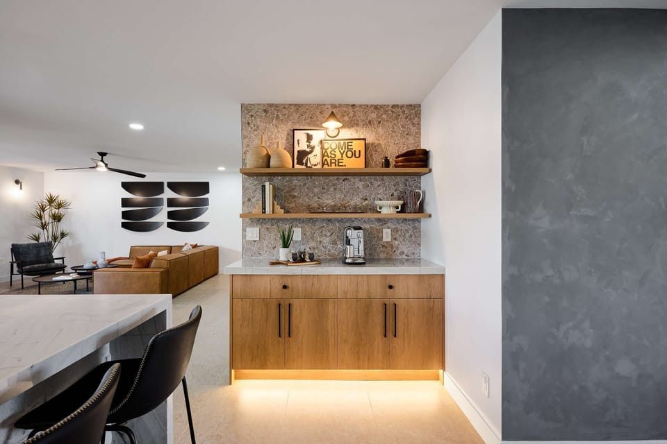 Sleek open concept kitchen with stainless steel appliances,  large island with breakfast bar seating for 5, coffee bar with espresso machine,  and fully equipped with your basic cooking essentials. 