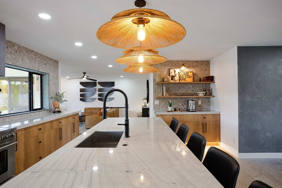 Sleek open concept kitchen with stainless steel appliances,  large island with breakfast bar seating for 5, coffee bar with espresso machine,  and fully equipped with your basic cooking essentials. 