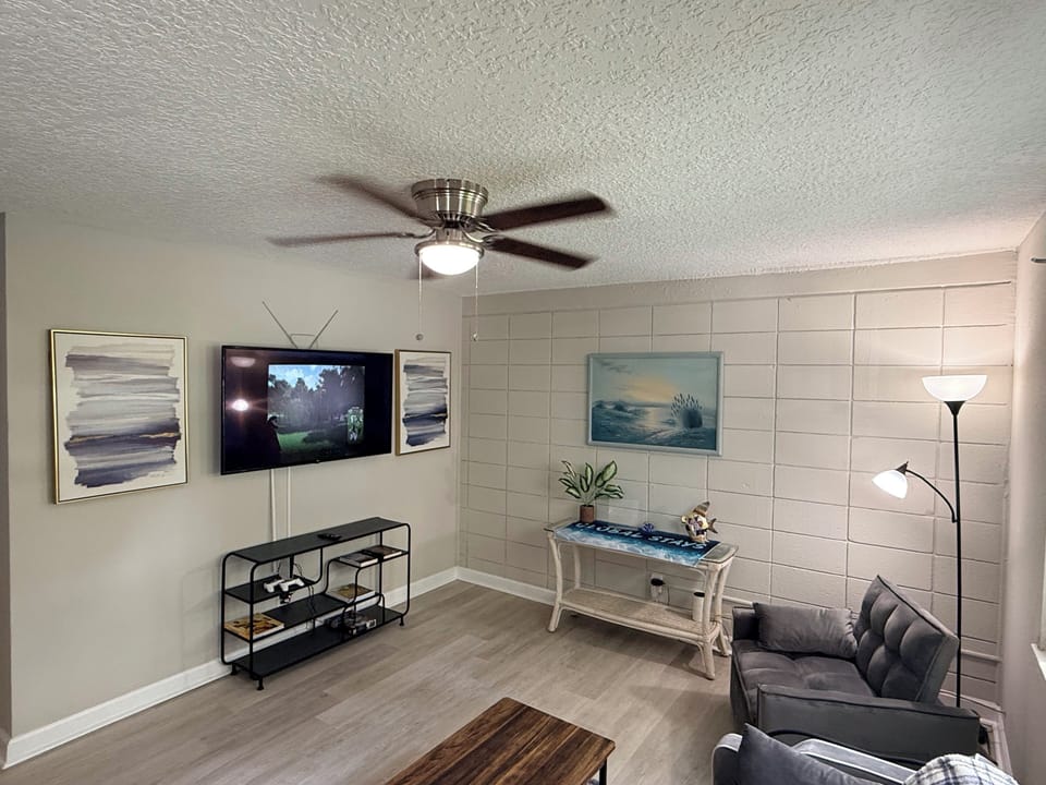 Cozy, updated living room with TV, comfy seating, and coastal touches