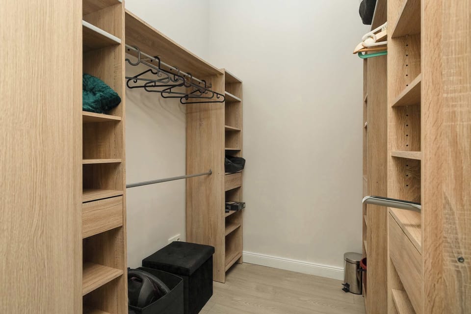 A spacious built-in wardrobe with plenty of shelves and hanging space. The storage area makes it easy to keep clothes and belongings organized.