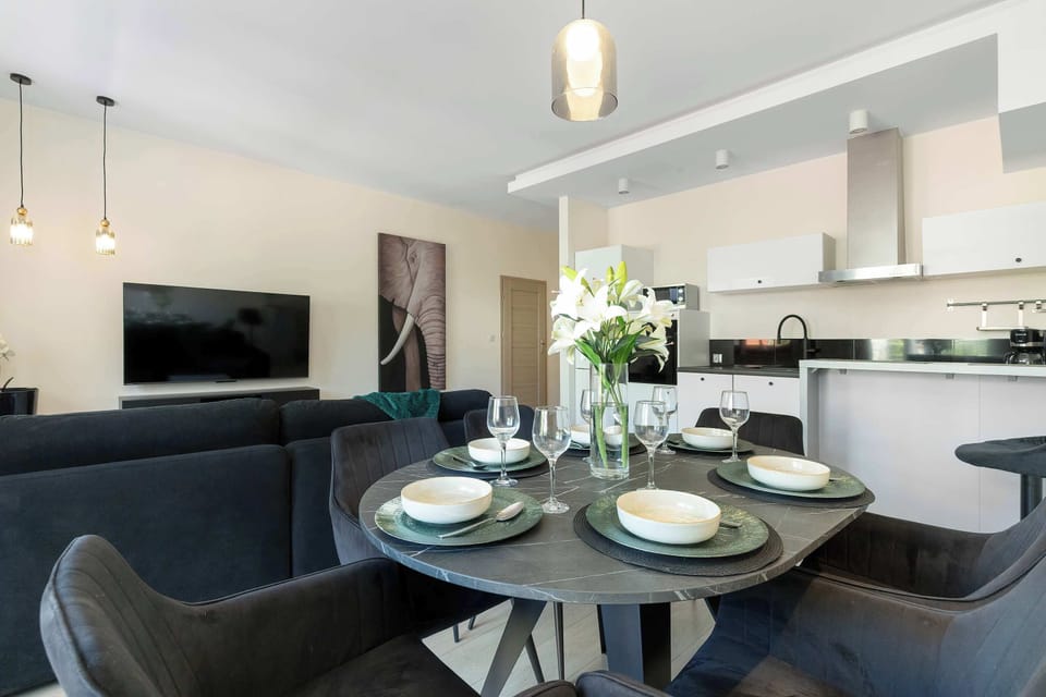 A dining area connected to the kitchen, featuring a round table and comfortable chairs. The elegant decor creates a pleasant setting for shared meals.