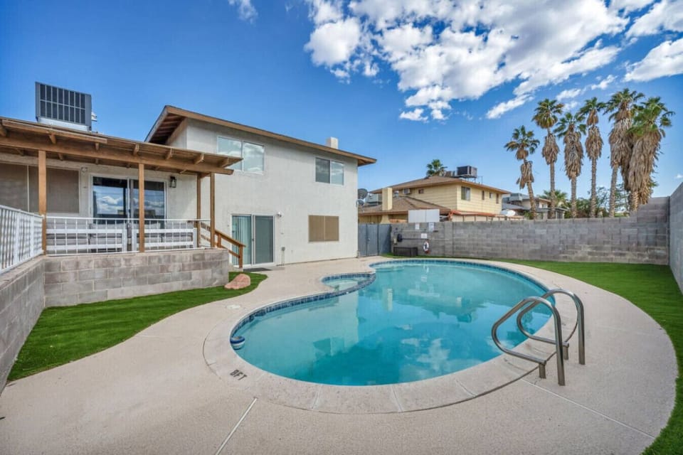 Take a dip in your private kidney-shaped pool, perfect for family fun or lounging under the palms. Surrounded by lush turf and complete with a safety rail, it`s your own serene oasis under the desert sky.