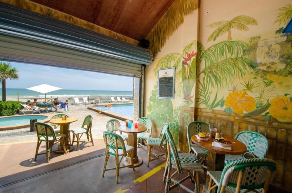 Open-air poolside dining with tropical décor and ocean views
